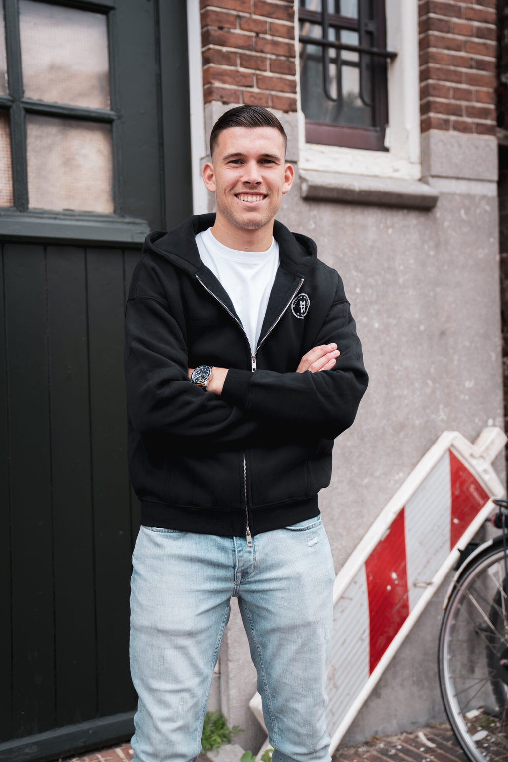 Man draagt het Motive Vest Zwart van Modern Motive met minimalistisch design en ritssluiting
