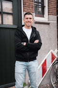Man draagt het Motive Vest Zwart van Modern Motive met minimalistisch design en ritssluiting