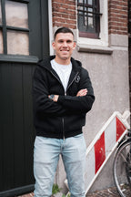 Man draagt het Motive Vest Zwart van Modern Motive met minimalistisch design en ritssluiting