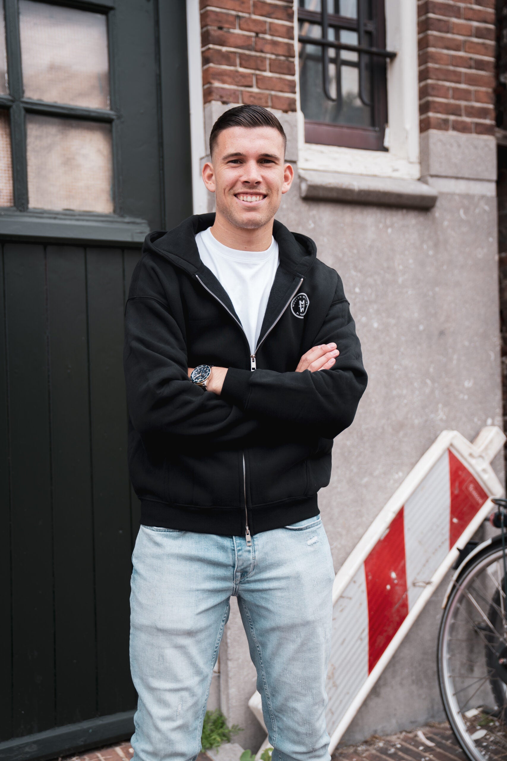 Man draagt het Motive Vest Zwart van Modern Motive met minimalistisch design en ritssluiting