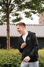 Man draagt het Motive Vest Zwart van Modern Motive met minimalistisch design en ritssluiting